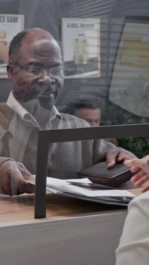 Elderly Customer Pointing and Explaining Documents to Teller Stock Footage 330965568