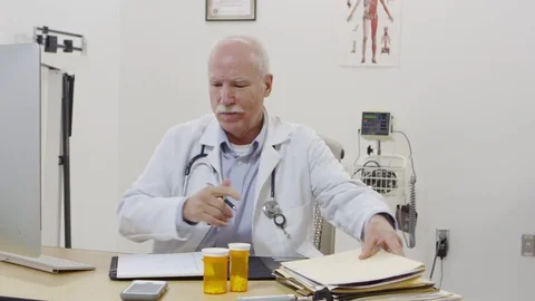 Elderly doctor calling and using cellphone Stock-Footage 80128862