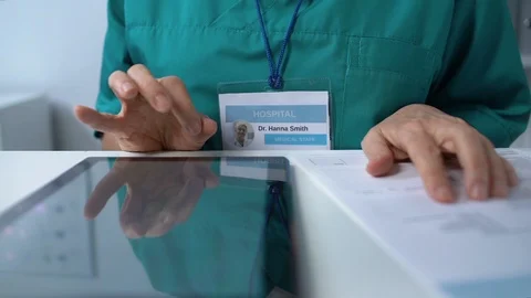 Elderly doctor typing on tablet PC, filling data in online medical records 動画素材 118907316