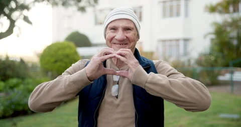 Elderly, face and happy man with heart hands in garden for retirement, love or 動画素材 340605903