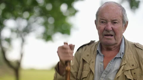Elderly farmer talking and gesturing in the countryside Stock Footage 328348701