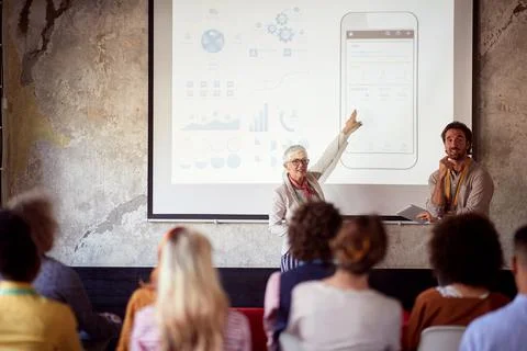 Elderly female lecturing students together with her male assistant, showing,  Stock Photos