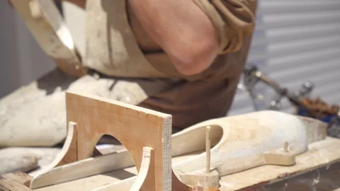 Elderly gray-haired benevolent master carpenter tries on wooden details. 動画素材 128326004