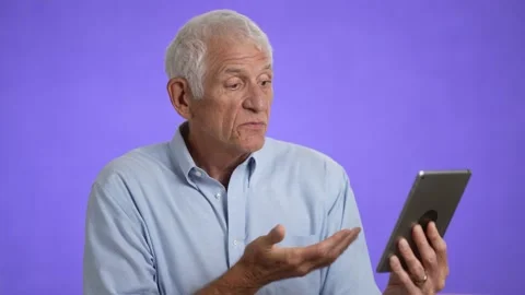 Elderly gray-haired man 70s in blue shirt using tablet computer for telehealth Stock Footage 213283280