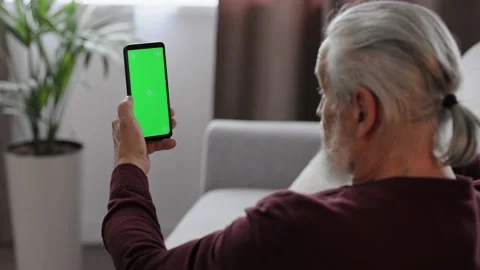 Elderly gray-haired man making video call at smartphone camera green screen Stock Footage 197413074