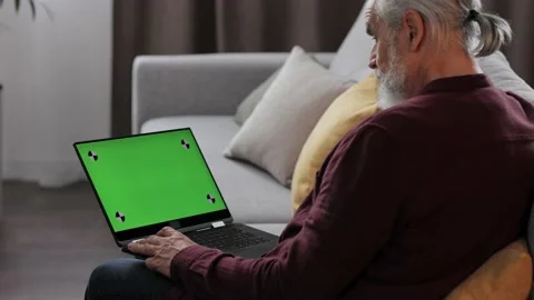 Elderly gray-haired man making video call at laptop green screen. Senior man Stock Footage 197413118