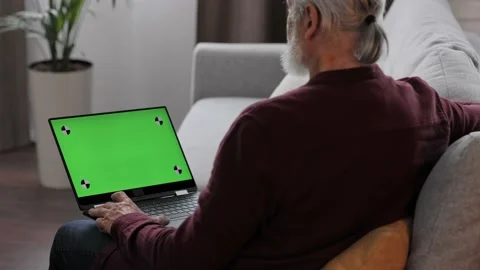 Elderly gray-haired man making video call at laptop green screen. Senior man Stock Footage 219645014