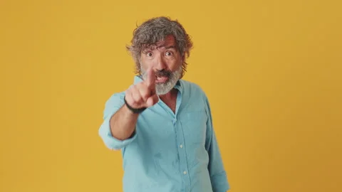 Elderly gray-haired man points with forefinger and raising thumb up, isolated on Stock Footage 252031070