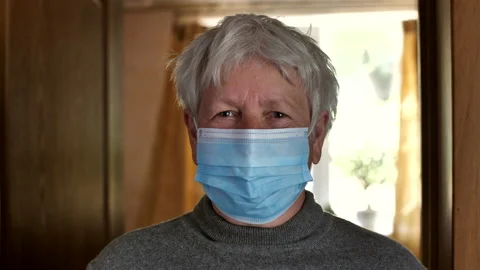 An elderly, gray-haired woman in a respiratory protective mask. covid-19 Stock Footage 130536853