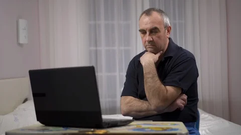 Elderly grey-haired male using laptop, watching football on a laptop and gets Stock Footage 106093475