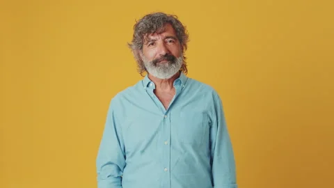 Elderly grey-haired man looking at camera showing ok gesture, isolated on orange Stock Footage 250841159