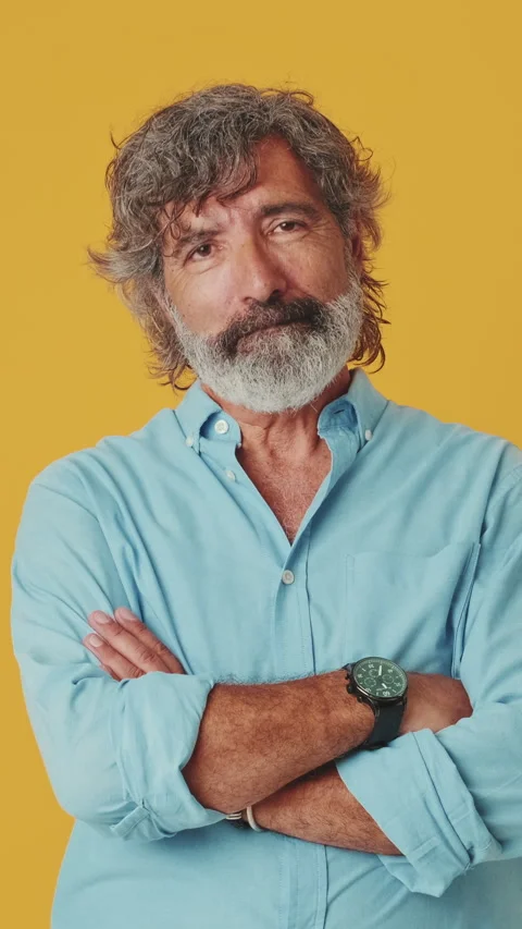 Elderly grey-haired man looking at camera showing thumbs up, isolated on orange Stock Footage 252207460
