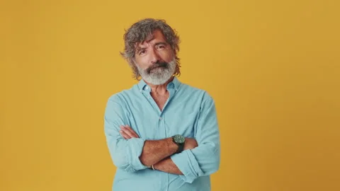 Elderly grey-haired man looking at camera showing thumbs up, isolated on orange Vídeo Stock 252207515