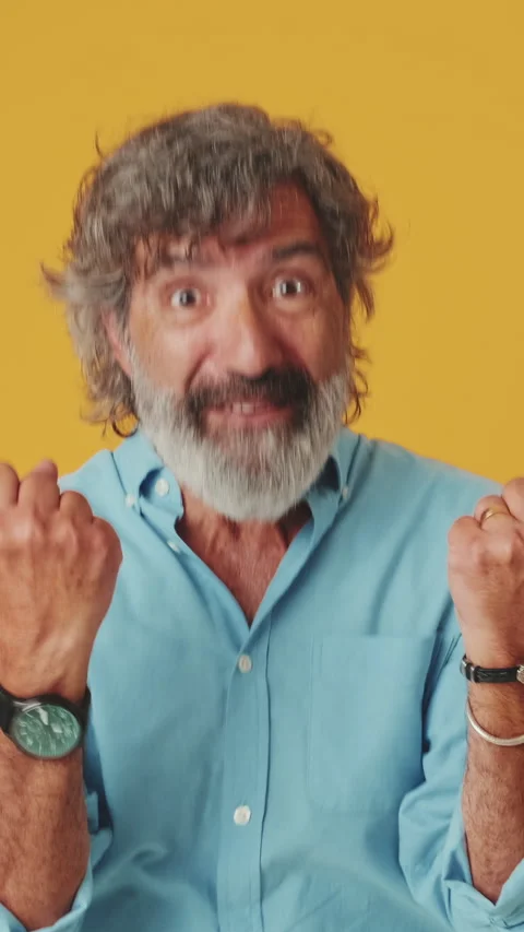 Elderly grey-haired man raises his fists in the gesture I did it, isolated on Stockbeeldmateriaal 252503224
