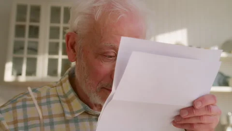 Elderly grey haired man sits at table with papers Stock Footage 264838949