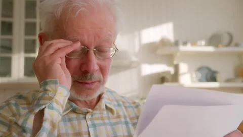 Elderly grey haired man sits at table with papers Stock Footage 264839808