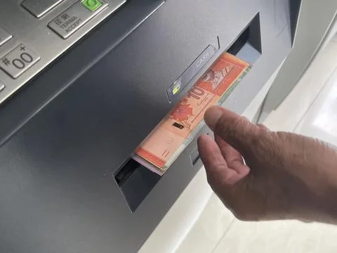 Elderly Hand Collecting Malaysian Ringgit Cash from ATM Dispenser Foto stock