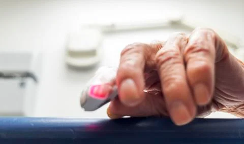 Elderly hand with a pulse meter. Stock Photos