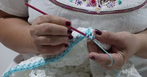 Elderly hands knitting the border in blue cotton yarn with stretchy pattern Stock Footage 205310284