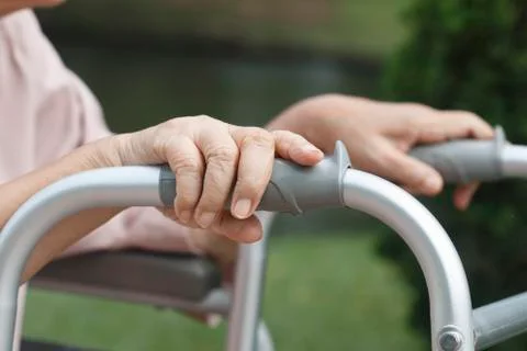 Elderly hands on a walker. Stock Photos