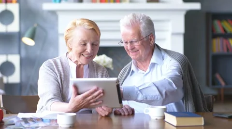 Elderly happy couple working on tablet in modern apartment Stock Footage 63324295