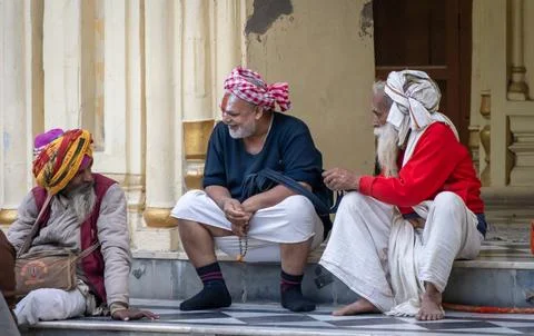 Elderly Hindu devotees engaged in conversation at temple courtyard in Ayodhya Stock Photos