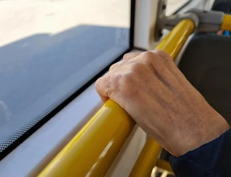 An elderly human holds onto the railing Stock Photos
