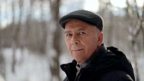 Elderly human is walking in forest in winter day, old man is exhaling cold air Video stock 169356452