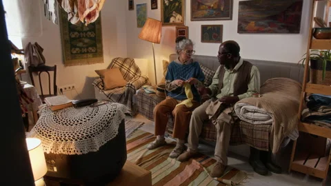 Elderly Interracial Couple Chatting While Knitting and Watching Retro TV 스톡 동영상 314623022