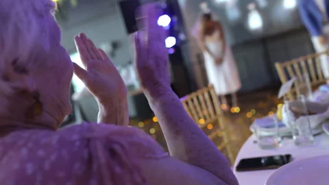 An elderly lady claps at the holiday table Stock Footage 250624537