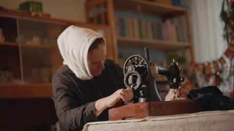 Elderly lady engaging in precise hand sewing at home. Senior woman peacefully Stock Footage 346562642