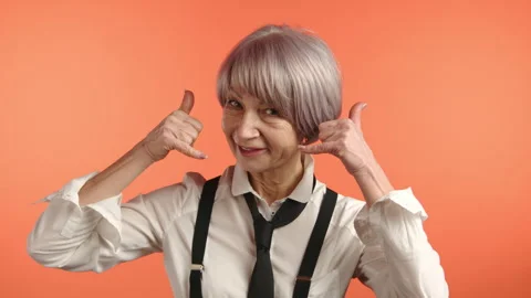 Elderly Lady Gesturing 'Call Me' with a Cheerful Smile Stock Footage 262078028