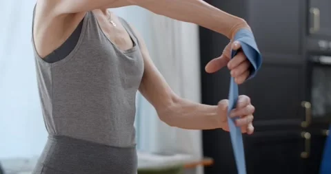 Elderly lady is going to do exercises with rubber bands at home, fitness Stock Footage 232305200