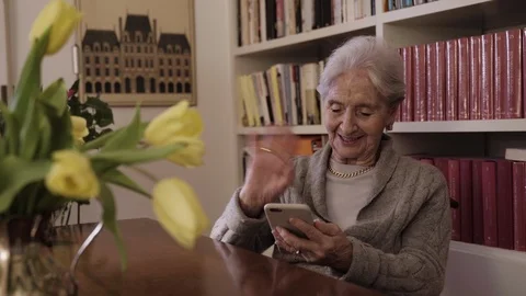 Elderly lady having a video call greets the family saying bye bye to smartphone Stock Footage