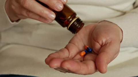 An elderly lady preparing to take her supplements. Stock Footage 302828272