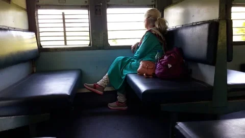 Elderly lady sitting alone inside Indian Railway coach 스톡 동영상 154947069