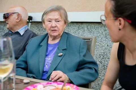 Elderly lady talking at the table to younger woman. Stock Photos