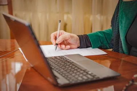 Elderly lady writing down orders, work from home Stock Photos