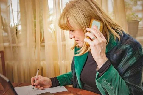 Elderly lady writing down orders, work from home Stock Photos