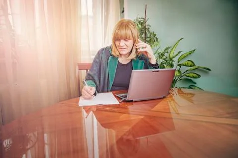 Elderly lady writing down orders, work from home Stock Photos