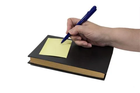 An elderly lady's hand making a note on a book Stock Photos