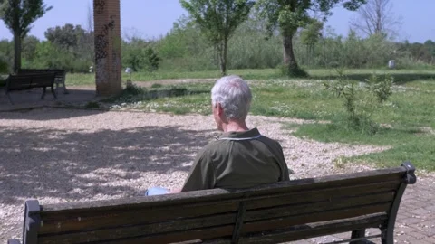 Elderly man alone on bench side back view abandonment feeling Stock Footage 333194733