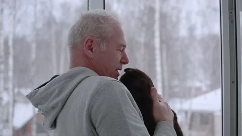 An elderly man and his cat look out the window Stock Footage 166877877