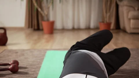 An elderly man with an athletic build exercises on a mat at home Video stock 333245495