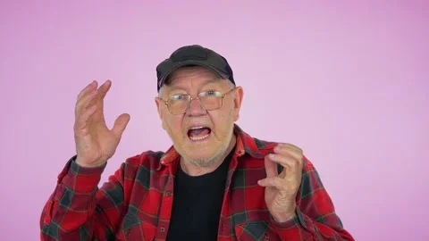 An elderly man, in a baseball cap and glasses, a red shirt, dances Stock Footage 279896826