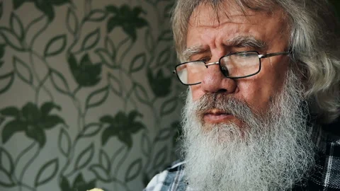 An elderly man with a beard in glasses bites an Apple. Healthy diet Stock Footage 86117721