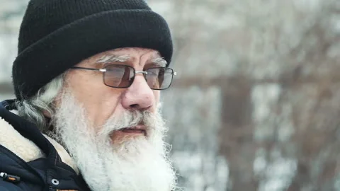 Elderly man with a beard in the hat and glasses, looking at the camera Stock Footage 85894659