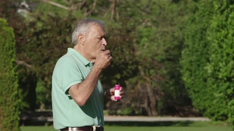Elderly man blowing bubbles in the park Video stock 80133536