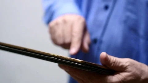 Elderly Man Browsing Online On Tablet, Close Up Stock Footage 73953105