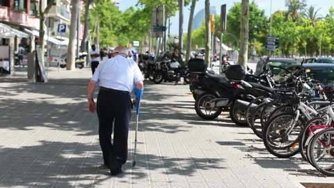 Elderly man with a cane and a face mask walking along the street in Barcelona. Stock Footage 133367169